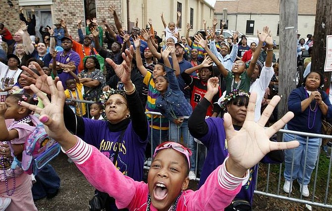 AP Photo/Ann HeisenfeltRhojohnae August, 9, front, and other revelers vie for throws from a float during the Krewe of Zulu Mardi Gras parade in New Orleans on Tuesday.