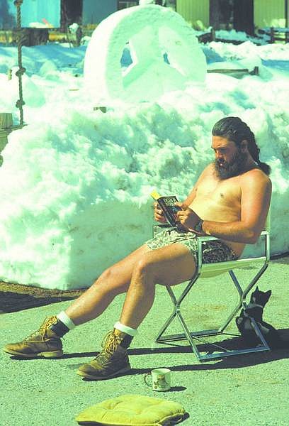 Tahoe Daily Tribune File Photo After a hard day shoveling snow from his South Lake Tahoe driveway, Scott Delvecchio takes time out with his cat to relax in the sun with a good book in this March 28, 1991, photo. In the background is a peace sign Delvecchio sculpted earlier that day.