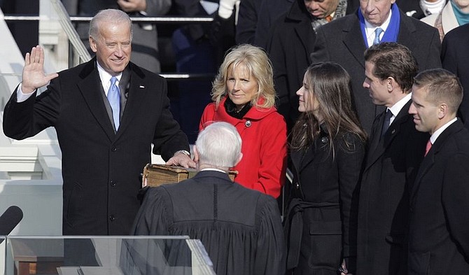 Vice President-elect Joe Biden, with his wife Jill at his side, takes the oath of office from Justice John Paul Stevens, as his wife holds the Bible at the U.S. Capitol in Washington, Tuesday, Jan. 20, 2009. At right are Biden&#039;s children Ashley, Hunter and Baeu, far right.  (AP Photo/Jae C. Hong)