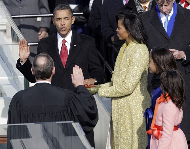 Barack Obama, left, joined by his wife Michelle, third from left, and daughters Sasha, fourth from left, and Malia, takes the oath of office from Chief Justice John Roberts to become the 44th president of the United States at the U.S. Capitol in Washington, Tuesday, Jan. 20, 2009.  (AP Photo/Jae C. Hong)