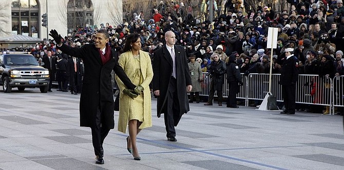 President Barack Obama and first lady Michelle Obama walk down Pennsylvania Avenue en route to the White House, Tuesday,  Jan. 20, 2009.   (AP Photo/Doug Mills, Pool)