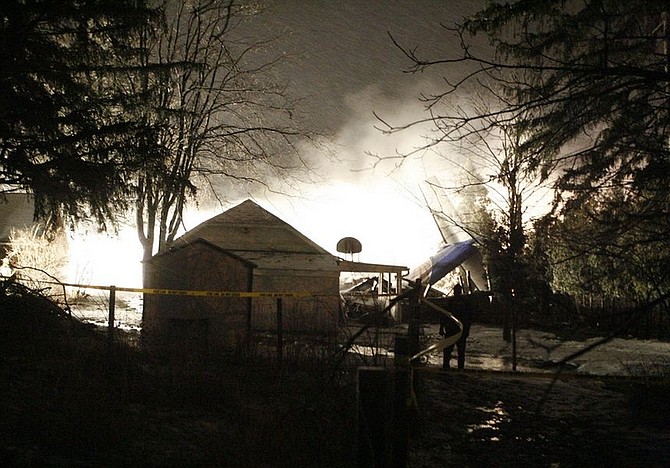 Firefighters spray and foam the scene where a  plane  crashed into a house and burned  in Clarence Center, N.Y., Thursday, Feb. 12, 2009 Tail Section visable .  Niagara  Frontier Transportation Authority spokesman said 44 passengers aboard with crew of 4 for total of 48 on board , no apparent survivors plus one fatality on the ground.(AP Photo by John Hickey )