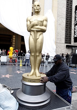 Production worker Frank Roach adjusts an Oscar statue on the back of a cart outside of the Kodak Theatre in Los Angeles on Tuesday, Feb. 17, 2009. The 81st Academy Awards will be presented Sunday, Feb. 22. (AP Photo/Matt Sayles)
