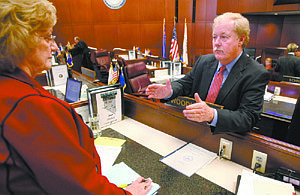 Nevada Sens. Joyce Woodhouse, D-Henderson, left, and Mike Schneider, D-Las Vegas, talk Wednesday, Feb. 25, 2009, following the Senate floor session at the Legislature in Carson City, Nev. Earlier Wednesday, Schneider introduced a measure that would allow police to ticket taxi cab passengers for not wearing seat belts. (AP Photo/Nevada Appeal, Cathleen Allison)
