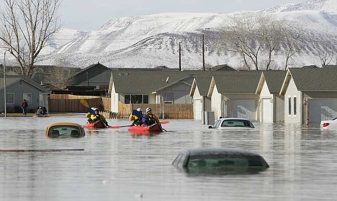 ** FOR RELEASE WEEKEND EDITIONS, MARCH 28-29 **FILE**In this Jan. 5, 2008 file photo, Reno rescue team members search a neighborhood in Fernley, Nev., after a canal levee ruptured from heavy rainfall. The failure of a century-old earthen canal in northern Nevada that sent flood waters into hundreds of homes on a frigid night in January 2008 was only the beginning of a nightmare for a rural irrigation district.  (AP Photo/Nevada Appeal, Brad Horn)