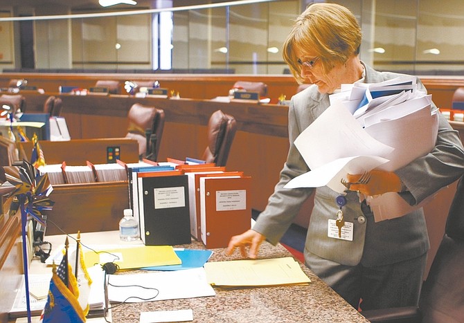 Nevada Assembly Sergeant at Arms Mary Mathews clears piles of paperwork off Assembly desks Tuesday afternoon, April 21, 2009, at the Legislature in Carson City, Nev., after lawmakers met a deadline for sending bills from one house to the other. (AP Photo/Nevada Appeal, Cathleen Allison)
