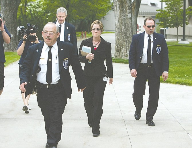 Lauren Soper, of the Legislative Counsel Bureau, delivers SB429 to Nevada Gov. Jim Gibbons on Friday, May 22, 2009, in Carson City, Nev. Pictured from left, clockwise, are Legislative Police Officers Nick Gillen, John Drew, and Dennis Tucker.