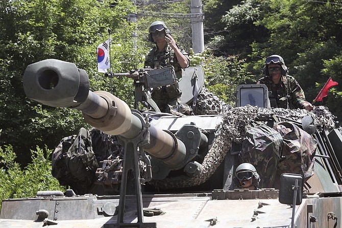 South Korean Army soldiers ride in a self-propelled artillery vehicle during a drill against a possible attack from North Korea near the demilitarized zone separating the two Koreas in Jeongok, South Korea, Friday, June 12, 2009. South Korea is bracing for a possible third nuclear test by North Korea, which a U.S. official says is likely despite looming U.N. sanctions on the communist state for its previous test in May.(AP Photo/Ahn Young-joon)