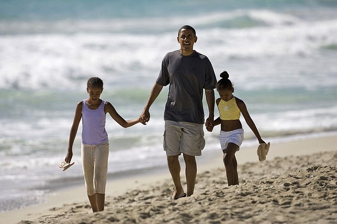 FILE -- In this Aug. 12, 2008 file photo, then Democratic presidential candidate Sen. Barack Obama, D-Ill. walks down Kailua Beach in Kailua, Hawaii, with his daughters Malia, 10, left, and Sasha, 7, during their vacation in Hawaii.  (AP Photo/Marco Garcia, File)