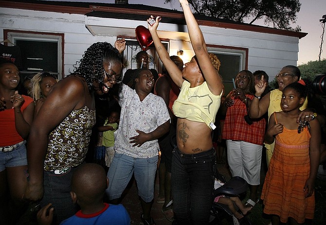 People dance and sing Michael Jackson songs as they gather in front of  his childhood home in Gary, Ind. Thursday, June 25, 2009 following the news of Jackson&#039;s death. (AP Photo/John Smierciak)
