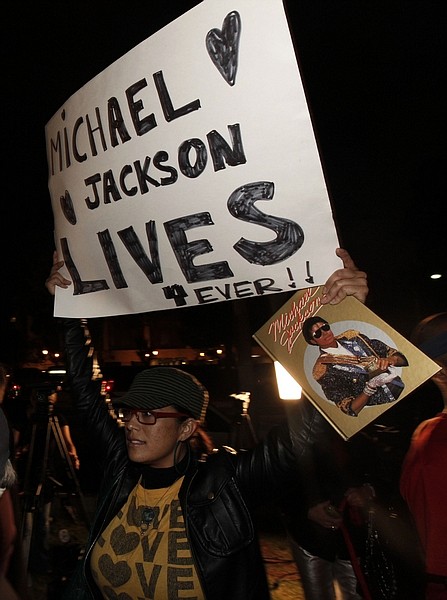An unidentified fan holds a poster outside the UCLA Medical Center, where entertainer Michael Jackson was taken, in Los Angeles, Thursday, June 25, 2009.  Jackson, the sensationally gifted child star who rose to become the &quot;King of Pop&quot; and the biggest celebrity in the world only to fall from his throne in a freakish series of scandals, died Thursday. He was 50. (AP Photo/ Matt Sayles)