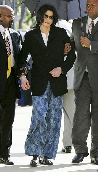 FILE -- In a March 10, 2005 file photo Michael Jackson, wearing pajama pants, is helped as he walks to the courthouse in Santa Maria, Calif., after arriving late.  Jackson said his attire and tardiness was the result of a morning stay at a local hospital for back pain. Jackson died Thursday June 25, 2009 in Los Angeles.  (AP Photo/Kimberly White, Pool/file)