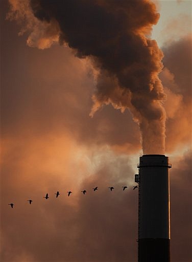 FILE - The Jan. 10, 2009 file photo shows a flock of geese flying past a smokestack at the Jeffery Energy Center coal power plant near Emmitt, Kan.. Sweeping legislation to curb the pollution linked to global warming and create a new energy-efficient economy is headed to an uncertain future in the Senate after squeaking through the House. The vote was a big win for President Barack Obama, who hailed House passage as a &quot;historic action.&quot; &quot;It&#039;s a bold and necessary step that holds the promise of creating new industries and millions of new jobs, decreasing our dangerous dependence on foreign oil and strictly limiting the release of pollutants that threaten the health of families and communities and the planet itself,&quot; Obama said in a statement on Friday, June 26, 2009.  (AP Photo/Charlie Riedel, File)