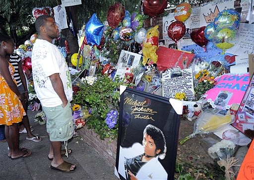 Actor Anthony Anderson looks at a memorial for Michael Jackson in front of the Jackson family home, Saturday, July 4, 2009, in the Encino section of Los Angeles.  (AP Photo/Mark J. Terrill)