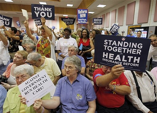 Constituents of Congressman Tom Perriello, D-Va., holds signs as they listen to the congressman during a town hall meeting on Health Care at the Fluvanna Middle School in Fork Union, Va., Monday, Aug. 17, 2009.  Perriello is one of three dozen Democratic Freshmen that have been thrown into the center of one of the most contentious policy debates in years. (AP Photo/Steve Helber)