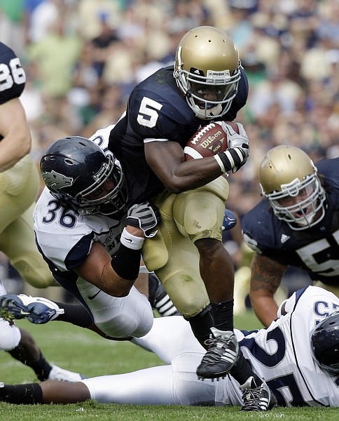 Notre Dame running back Armando Allen Jr. (5) is tackled by Nevada linebacker Mike Bethea in the first quarter during NCAA college football game in South Bend, Ind., Friday, Sept. 4, 2009. (AP Photo/Michael Conroy)