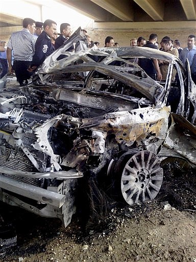 People gather around a destroyed car after a suicide car bomber targeted a checkpoint in Ramadi, 115 kilometers (70 miles) west of Baghdad, Iraq, Monday, Sept. 7, 2009. The car exploded as vehicles were waiting to be inspected before crossing a bridge near the provincial capital of Ramadi, a police officer said. The dead included three police officers; the others were civilians, police said. (AP Photo)