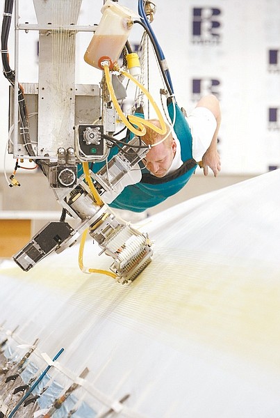 Rodney Schilling is attached to the gantry as the fiber head lays the yarn on the mold.