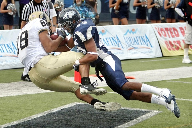 Nevada defender Jonathon Amaya, right, knocks the ball loose from Idaho receiver Daniel Hardy in the second half of an NCAA college football game, Saturday Oct. 24, 2009, in Reno, Nev. Nevada won 70-45.  (AP Photo/Cathleen Allison)
