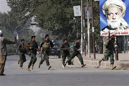 Afghan security forces rush to the site of a firing by suicide attackers in Jalalabad, Nangarhar province, east of Kabul, Afghanistan  on Monday, Oct. 26, 2009. Nangarhar province Gov. Gul Agha Sherzai survived an assassination attempt after a gunman fired automatic weapons at his convoy from a hotel window as his convoy drove down a road in Jalalabad, according to his spokesman Ahmad Zia Abdulzai. Sherzai&#039;s bodyguards killed the gunman, as well as another attacker wearing a suicide vest and carrying grenades. (AP Photo//Rahmat Gul)