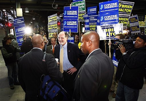 New Jersey Gov. Jon S. Corzine, center, talks with commuters as he campaigns, Monday, Nov. 2, 2009, in Hoboken, N.J. Corzine will face Republican candidate Chris Christie and Independent candidate Chris Daggett in Tuesday&#039;s election. (AP Photo/Mel Evans)