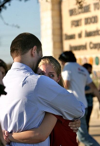 Daniel Clark hugs and comforts his wife Rachel Clark outside of the main gate of Fort Hood near Killeen, Texas, Thursday, Nov. 5, 2009. Daniel&#039;s daughter, Madeline, 5, is in an elementary school on the post where it was locked down after a shooting happened on the base. (AP Photo/Austin American-Statesman, Rodolfo Gonzalez) MAGS OUT, NO SALES, TV OUT, INTERNET OUT:AP MEMBERS ONLY