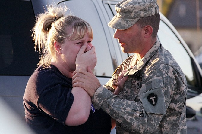 Sgt. Anthony Sills, right, comforts his wife as they wait outside the Fort Hood Army Base near Killeen, Texas on Thursday, Nov. 5, 2009. The Sills&#039; 3-year old son is still in daycare on the base, which is in lock-down following a mass shooting earlier in the day. (AP Photo/Jack Plunkett)