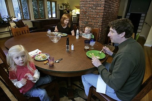 FILE - IN this April 30, 2008, file photo, Sean, right and Julia O&#039;Connell, rear left, have dinner in their Fox Chapel, Pa., home with their children Violet, 3, left, and Emmet. Instead of eating out two to three times a week, the O&#039;Connells limit trips for them and their two children to Friday nights, shaving their monthly restaurant bill from $400 to under $250. (AP Photo/Gene J. Puskar)