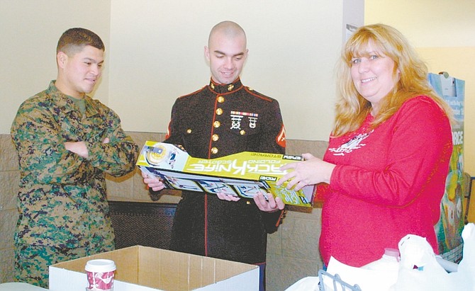 Sandi Hoover/Nevada Appeal Charise Whitt of Carson City stops to chat with Marine LCPL Pierce Toomey, center, and Marine Sgt. Ruben Garcia Saturday at the north Carson City Walmart as she donates a toy for the Toys for Tots annual drive.