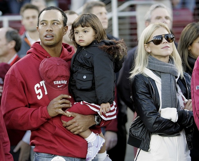 FILE - In this Nov. 21, 2009 file photo, Tiger Woods with his daughter Sam and wife Elin are seen before the start of a NCAA college football game between Stanford and California in Stanford, Calif. (AP Photo/Marcio Jose Sanchez, File)