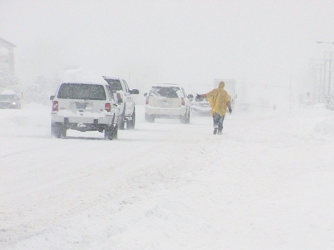 A hitchhiker walks north on Highway 395 in front of the Northgate Shopping Center.