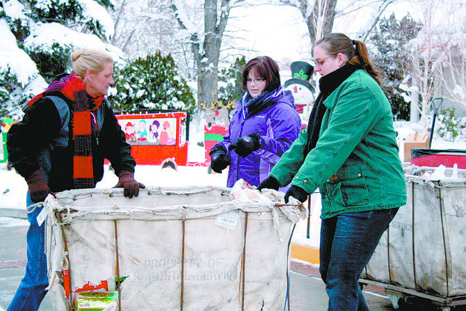 Wendi Spencer, Traci Trenoweth and Sarah Andrews move mail carts full of food donated during the annual Share Your Holiday Food Drive Friday at the Governor&#039;s Mansion.  Photo by Rhonda Costa