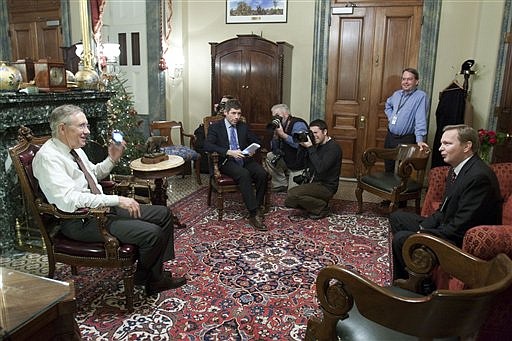 Senate Majority Leader Harry Reid, D-Nev., left, talks with staff during a photo-op in his office  prior to the first vote on the Health Care legislation on Capitol Hill in Washington, Monday, Dec. 21, 2009.  (AP Photo/Harry Hamburg)