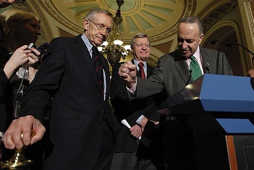 Senate Majority Leader Harry Reid of Nev., left,  listens as Sen. Charles Schumer, D-N.Y., right, drives home a point while answering questions on Capitol Hill in Washington, Thursday, Dec. 24, 2009, after the Senate passed the health care reform bill. Senate Finance Committee Chairman Sen. Max Baucus, D-Mont. is at center.  (AP Photo/Manuel Balce Ceneta)