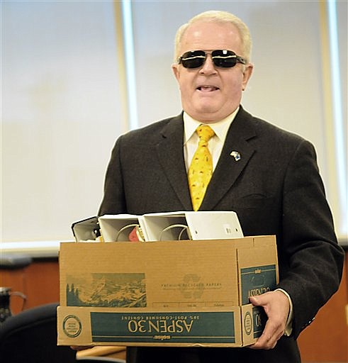 Following the settlement court hearing, Nev.  Gov. Jim Gibbons carries one of the many boxes his attorney was prepared to use to present his case Monday Dec. 28, 2009 in Reno.  The case was settled just before the trial was to have begun.  (AP Photo/The Gazette-Journal, Marilyn Newton)