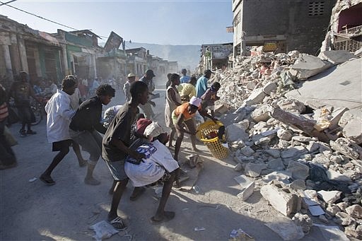 People fight over goods scavenged from the rubble of buildings collapsed during Tuesday&#039;s earthquake  in Port-au-Prince, Friday, Jan. 15, 2010. (AP Photo/Ramon Espinosa)