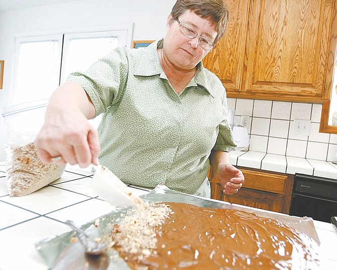 Mindy Miller of Ruhenstroth puts a final layer of amonds on a small batch of toffee she made at home on Friday, Jan. 29.