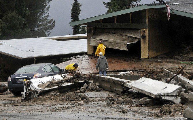 People survey damage to a home hit by mudslides and flooding in La Canada Flintridge, Calif., Saturday, Feb. 6, 2010. (AP Photo/Los Angeles Daily News, John McCoy) ** NO SALES; MAGS OUT; HILLS OUT, LOS ANGELES TIMES OUT; VENTURA COUNTY STAR OUT; ANTELOPE VALLEY PRESS OUT **