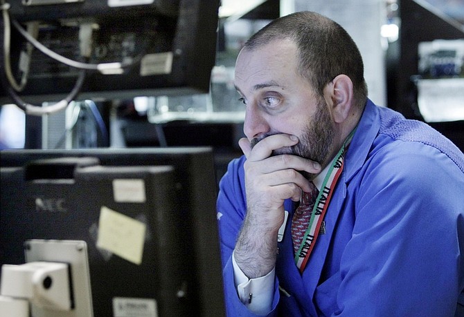 Specialist Peter Giacchi studies his screens as he works at his post on the floor of the New York Stock Exchange Thursday, Feb. 4, 2010. (AP Photo/Richard Drew)