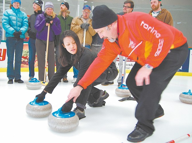 Brian Duggan/Nevada AppealEric Hazard shows Juliette Dao how to curl at a clinic for the Olympic sport in the South Lake Tahoe Ice Arena.