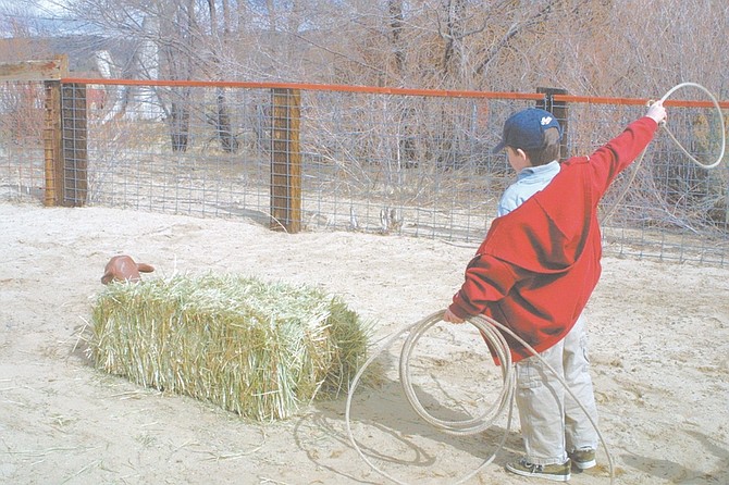Sandi Hoover/Nevada Appeal John Michael List, 7, of Carson City, tries to rope a cow made of hay during a Bureau of Land Management wild horse and burro adoption day at the Silver Saddle Ranch.