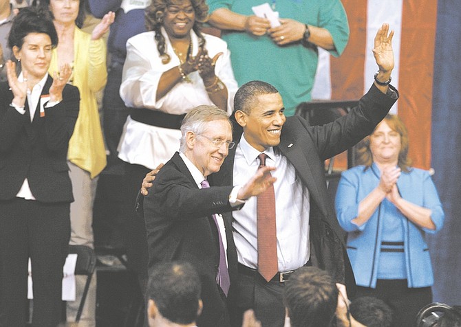 Senate Majority Leader Harry Reid of Nev. and President Barack Obama wave to the crowd following a town hall meeting at Green Valley High School in Henderson, Nev., Friday, Feb. 19, 2010. (AP Photo/Laura Rauch)