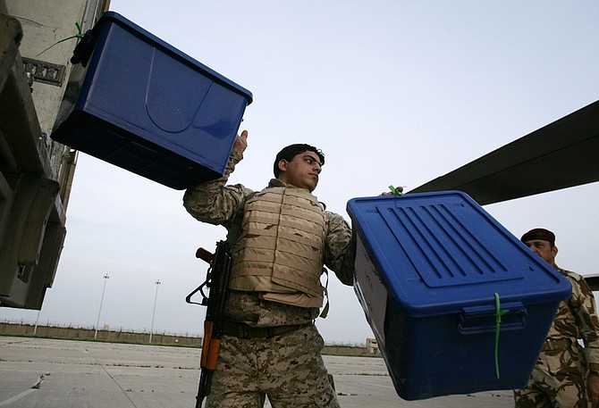 An Iraqi Army soldier carries a box of ballot tally sheets from Ninevah province for the national election to an Iraqi military cargo plane bound for Baghdad, in Mosul, north of Baghdad, Iraq, Monday, March 8, 2010. (AP Photo/Maya Alleruzzo)