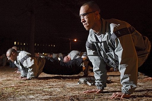 Private First Class, Jon Holverstott, front, from Kilean, Texas, performs performs one leg push-ups, that are included in the Army&#039;s new physical training regimen, during early morning physical training with the rest of along with other members of third platoon, at Fort Jackson in Columbia, S.C., Wednesday, Feb. 24, 2010. (AP Photo/Brett Flashnick)