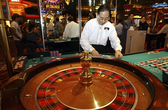 FILE - In this July 4, 2006 file photograph, Tommy Yu, a roulette dealer at Resorts Atlantic City casino, counts chips during play in Atlantic City, N.J. According to a new poll released Thursday, March 11, 2010, a majority of Americans oppose changing the law to allow bets to be placed over the Internet, as well as to allow legal betting in professional or college sports teams. The Fairleigh Dickinson University PublicMind poll also found people have positive opinions of Las Vegas, Atlantic City, and most other gambling resorts, with only Detroit receiving a negative rating. (AP Photo/Mary Godleski, File)