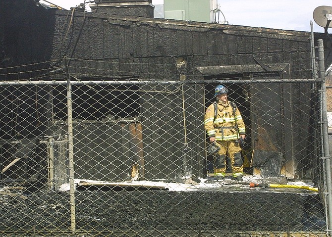 A fire fighters stands in the doorway of a storage unit attached to a furniture store destroyed in a fire Monday afternoon on Fairview Drive. The cause is under investigation.