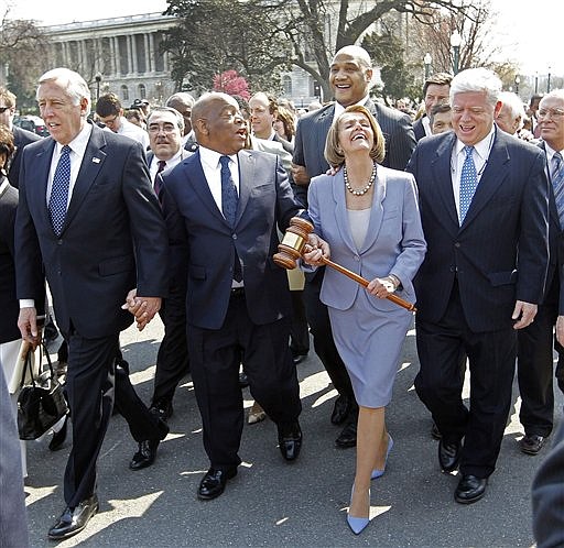 Speaker Nancy Pelosi  of California holding the gavel used to pass Medicare Reform, laughs as she walks across the street and into the U.S. Capitol as the House prepares to vote on health care reform in the U.S. Capitol in Washington, Sunday, March 21, 2010. Walking with Speaker Pelosi are from left, Rep. Steny Hoyer, D-Md., Rep. John Lewis, D-Ga., and Rep. John Larson, D-Conn. (AP Photo/Charles Dharapak)