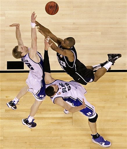 Butler&#039;s Willie Veasley, right, shoots over Duke&#039;s Brian Zoubek (55) and Kyle Singler, left, during the first half of the men&#039;s NCAA Final Four college basketball championship game Monday, April 5, 2010, in Indianapolis. (AP Photo/Michael Conroy)