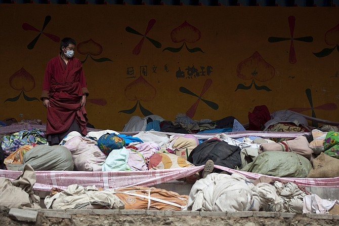 A monk looks at victims&#039; bodies to be claimed by family members for Tibetan burials near the Jiegu Monastery in Jiegu town, earthquake-hit Yushu, west China&#039;s Qinghai province, Friday, April 16, 2010. Rescuers probed the rubble for sounds or movement Friday in a rush to find anyone buried alive more than 48 hours after an earthquake hit western China, killing hundreds of people. (AP Photo/Alexander F. Yuan)