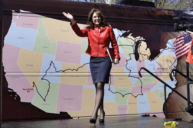Sarah Palin waves to a crowd as she passes a road map of the Tea Party Express, prior to her address on Boston Common in Boston, Wednesday, April 14, 2010. (AP Photo/Charles Krupa)